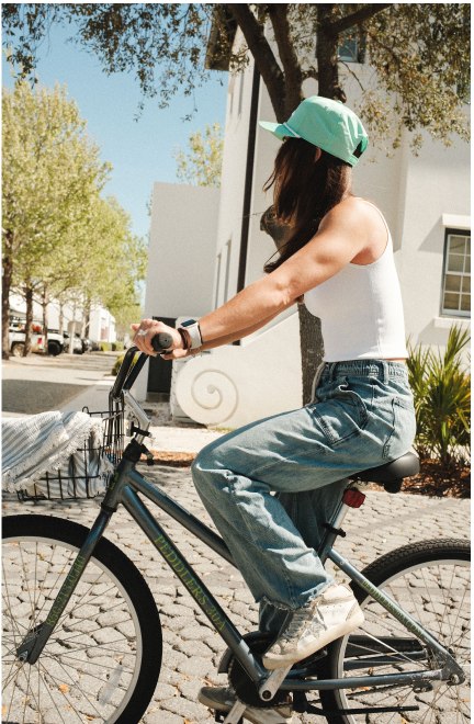 A rider on a multi-speed bike along a shaded street