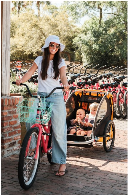 A parent riding with a child trailer attached