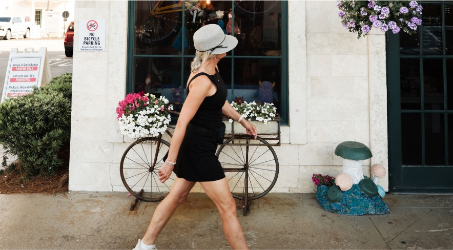 A guest walking past a bike outside a boutique
